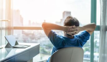 Office worker reclining in a chair at his desk