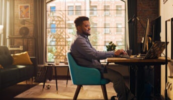 Happy man working productively from home in sunny stylish apartment