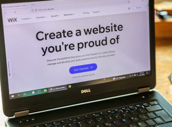 Laptop with Wix website builder on the screen on wooden table