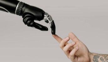 Robot and human hands touch to represent AI in the workplace.