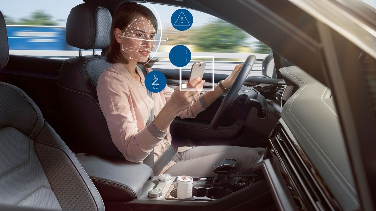 Distracted woman uses a phone while driving
