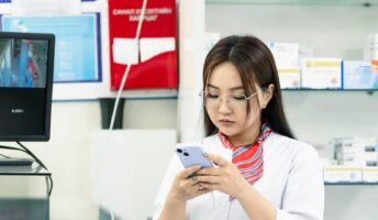 Worker on her phone at a pharmacy